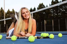 a woman laying on the ground with tennis balls and racquets in front of her