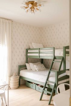 a bunk bed sitting next to a window in a room with white walls and wooden floors