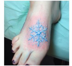 a snowflake tattoo is on the foot of a woman's foot,