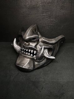 Black Mempo mask is a perfect addition to your interior decor and a standout accessory for any cosplay event, carnival or photoshoot, this mask is sure to impress wherever you wear it. Not only is it comfortable to wear, but you can also customize the colors and paint design to your exact preferences, making it a perfect fit for any occasion. Whether you're attending a Halloween party or simply love Japanese culture, this mask is the ideal gift for yourself or a friend. And if you have a specifi Oni Half Mask, Mempo Mask, Menpo Mask, Armour Cosplay, Kabuki Mask, Mascara Oni, Samurai Armour, Samurai Mask, Samurai Artwork