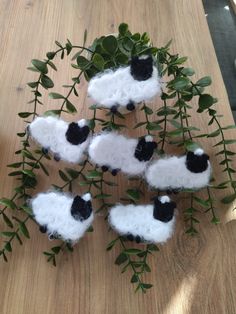 woolly sheep sitting on top of green leaves in the shape of a tree branch