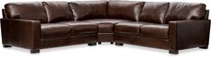 a brown leather sectional sofa sitting on top of a white floor