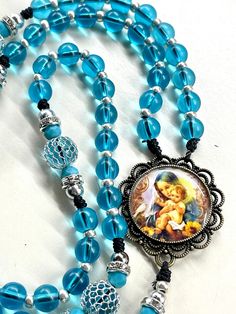 Welcome to my shop, Creating Still Moments Please visit my shop for other listings and opportunities to complete your holiday shopping  Thanks for visiting My entire Etsy shop is currently 20% off if you're looking to do some holiday shopping  https://www.etsy.com/shop/CreatingStillMoments?ref=sh-carousel-1  Handmade Rosary Immaculate Mary and Jesus bronze centerpiece Blue Glass beads blue mesh Pater beads  Indulgence bronze crucifix Blue rosary Catholic gift  Catholic gift confirmation gift God Blue Beaded Rosary As A Gift, Blue Rosary With 8mm Beads In Cross Shape, Adjustable Blue Beaded Rosary, Handmade Blue Rosary For Jewelry Making, Spiritual Blue Rosary With 108 Beads, Blue 108 Beads Spiritual Rosary, Blue Cross Rosary For Gift, Handmade Blue Rosary With Cross, Blue Cross Rosary As Gift