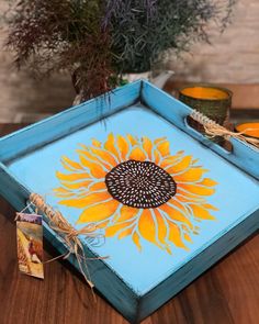 a blue tray with a yellow sunflower painted on it