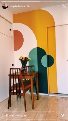 a dining room table and chairs in front of a wall with circles painted on it