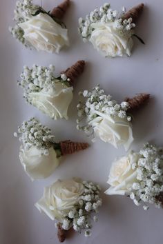 small white flowers are arranged on a table