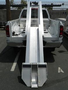 the back end of a white truck parked in a parking lot