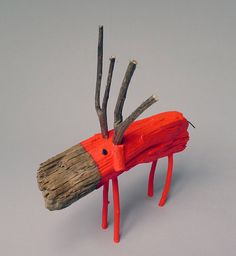 a wooden toy horse made out of sticks and wood with red paint on it's body