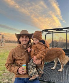 a man holding a small child in the back of a truck