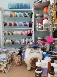 an assortment of crafting supplies are displayed on a table in a room with shelves