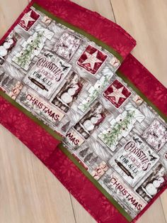 a red and white quilted placemat with christmas decorations on it, sitting on a wooden floor