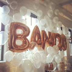 some balloons that say band and are hanging in front of a window with the word band on it