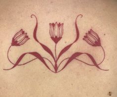 the back of a woman's neck with flowers drawn on her chest and in red ink