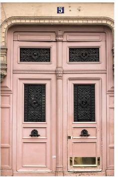 an old pink building with two large doors