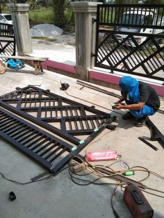 a man is working on some kind of metal structure that has been placed on the ground