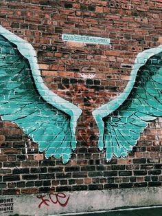 a brick wall painted with blue and white wings