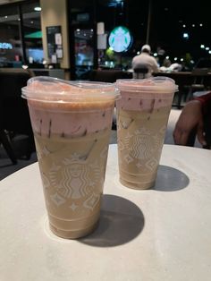 two starbucks drinks sitting on top of a table