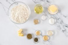 the ingredients to make this recipe are laid out on a marble counter top, including flour, butter, and eggs