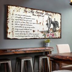 an old sign is hanging on the wall above a dining room table and bar stools