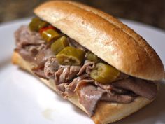 a sandwich with meat and peppers on a plate