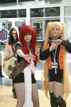 two women dressed in cosplay costumes standing next to each other and pointing at the camera