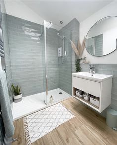 a bathroom with a shower, sink and mirror