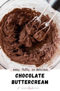 a mixing bowl filled with chocolate frosting on top of a wooden table