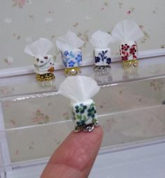 a hand is holding some small napkins in front of a drawer with other napkins on it