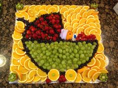 a cake made to look like an orange bird with fruit on the bottom and sides