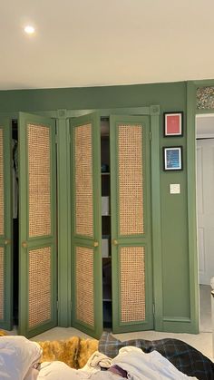 a bedroom with green walls and wicker doors