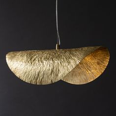 a gold colored light hanging from a black ceiling