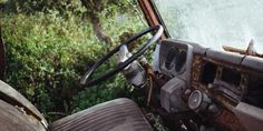 the interior of an old truck with trees in the background