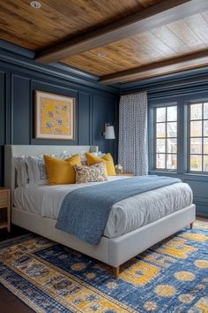 a bedroom with blue walls and yellow pillows on the bed, along with an area rug