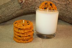 cookies and a glass of milk sitting on a table next to a tree branch with a candle in it