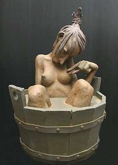 a statue of a woman sitting in a tub with her hands on her hips and holding a hammer