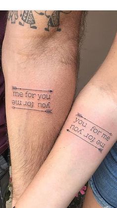 two people with tattoos on their arms and one is holding the other's arm