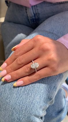 a woman's hand with yellow and white nails holding a ring on her finger