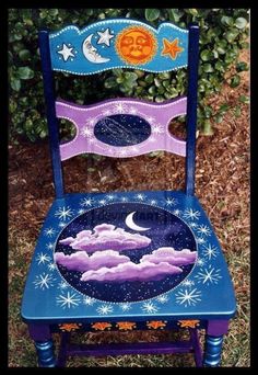 a blue chair with an image of the moon and stars painted on it's back