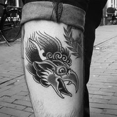 a black and white photo of a man's leg with a dragon tattoo on it