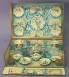 an open box with plates and cups in it's display case on a table