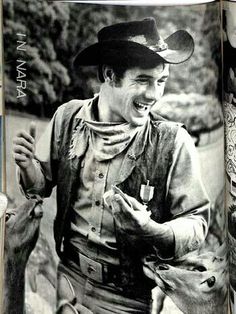 an old photo of a man holding a deer in his right hand and smiling at the camera