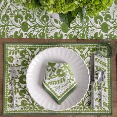 a place setting with green napkins and silverware