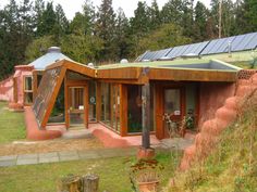 a house with solar panels on it's roof and windows in the front yard