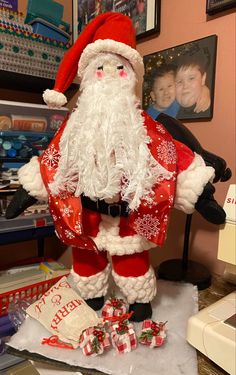 a santa clause figurine sitting on top of a table next to other christmas decorations