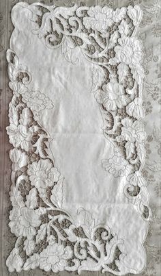 an old white lace with flowers on it