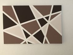 a piece of art hanging on the wall with brown and white squares in it's center