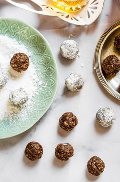 several different types of desserts on a plate next to a bowl of powdered sugar