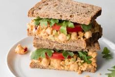 two sandwiches stacked on top of each other with lettuce, tomato and chickpeas