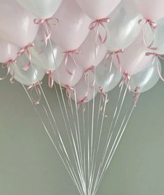 a bunch of pink and white balloons tied together