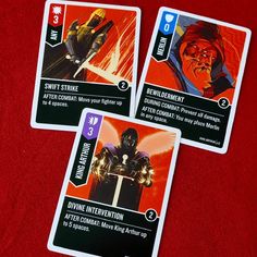 three star wars card game cards on a red surface